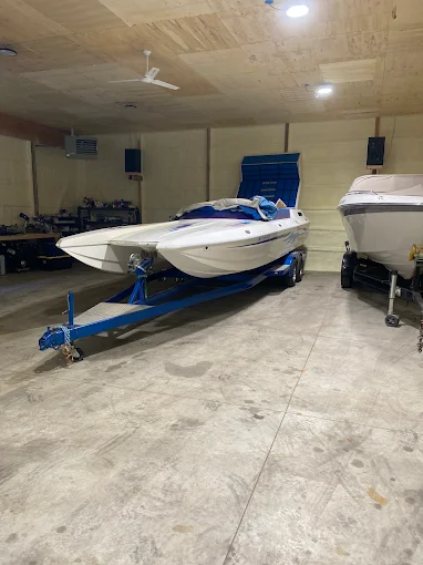 Performance catamaran boat on a blue trailer in the shop